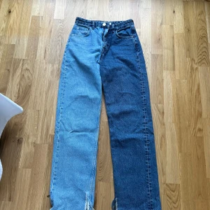 Tvåfärgade jeansbyxor från Pull&Bear - Unika jeansbyxor från Pull&Bear i två olika blå nyanser. Klassisk femficksmodell med raka ben och hög midja. Snygg kontrast mellan ljusblå och mörkblå denim, perfekt för dig som vill sticka ut.