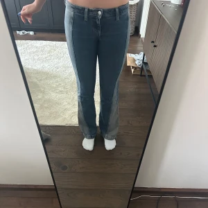 Blå bootcut jeans - Säljer ett par blå bootcut jeans med låg midja. Från weekday , pytte lite slitna längst ner där bak. Snygg tvätt med ljusare partier längs benen och  utsvängda ben. 