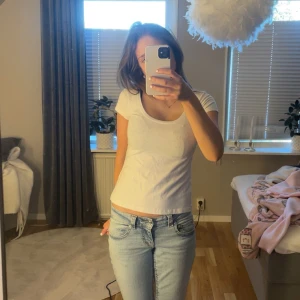 Vit t-shirt med rund hals - En basic vit t-shirt med rundad halsringning och korta ärmar. Modellen är figurnära och passar perfekt till jeans eller kjol. Enkel och stilren design utan tryck eller mönster.