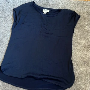 Mörkblå t-shirt - En enkel och stilren mörkblå t-shirt från Holly & Whyte. T-shirten har rund halsringning och korta ärmar, perfekt för en avslappnad look. Tillverkad i mjukt material som känns skönt mot huden.