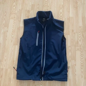 Mörkblå väst från Matterhorn - Säljer en mörkblå väst från Matterhorn i storlek medium. Västen har en dragkedja framtill och en bröstficka med dragkedja. Perfekt för lager-på-lager under kyligare dagar.
