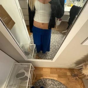 Blå lång kjol och tub klänning - Blå lång kjol och tub klänning. Går att vika ifall man vill ha den hög midjad eller extra låg midjad. Säljer då den inte kommer till användning. Från Hm förra året. Passar Xs-M då den är stretchig