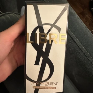 Libre Eau de Parfum Intense från Yves Saint Laurent - Säljer en elegant och intensiv parfym, Libre Eau de Parfum Intense från Yves Saint Laurent. Flaskan rymmer 90 ml och kommer i en stilren förpackning med guld- och svart detaljer. Perfekt för den som vill ha en djärv och sofistikerad doft.