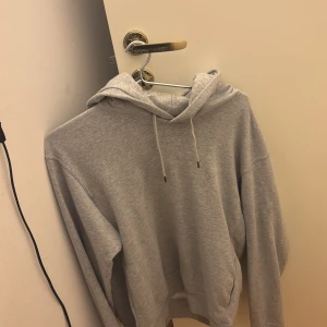 Grå Uniqlo hoodie - Säljer en perfekt vårhoodie i en mjuk grå färg. Hoodien är från uniqlo och kostade ungefär 500kr. Den är i bra skick och använd ett antal gånger sedan jul. Kom privat för ytterliggare frågor!!