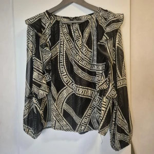 Topp  - En fin topp festlig med fina detaljer med mönster. 