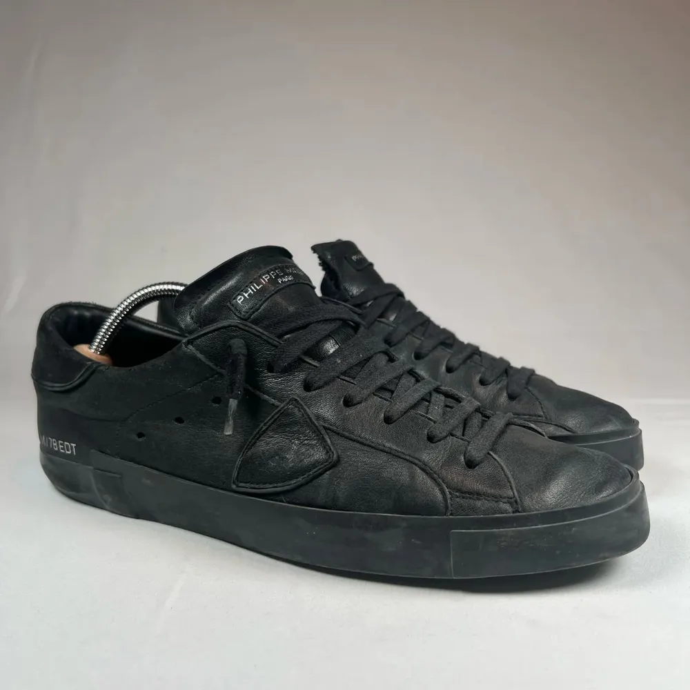 Snygga svarta sneakers från Philippe Model i skinn. De har en stilren design med snörning och diskreta detaljer. Perfekta för en casual look. Samt box med. Kengät.