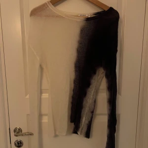 Svart och blå tröja från Weekday - Säljer en unik marinblå och vit tröja från Weekday i storlek M. Tröjan har en cool tvåfärgad design med en asymmetrisk look. Den är långärmad och gjord i ett lätt och luftigt material, perfekt för både vår och höst. Passar bra till både jeans och kjol!