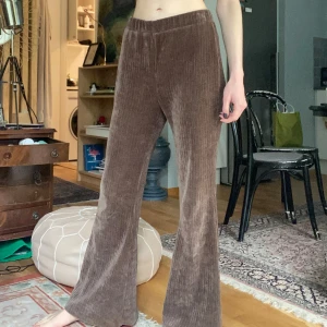 Bootcut brown 70’s pants - Brun-bronsiga byxor som är utsvängda à la 70-tal 🪩 Stretch, manchesterliknande. Hög midja med resår (kan skruva sig något). Går att vika ner i midjan. Gott men använt skick. Matchas gärna med den bronsfärgade toppen! Byxa & topp  80 kr.