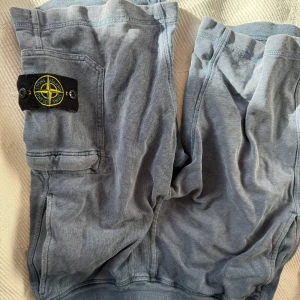 Stone Island shorts  - Stone Island shorts i en blå/grå färg med klassikt stone Island patch på vänster lår över en ficka samt 2 fickor på baksidan. Storlek S