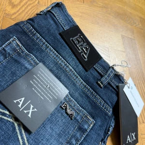 Blå jeans från Armani Exchange - Snygga blå jeans från Armani Exchange med klassisk femficksdesign och logotypdetaljer på bakfickan. Jeansen har en modern passform och är perfekta för en stilren look. De är tillverkade i ett slitstarkt denimtyg.