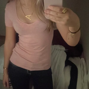 Rosa t-shirt med v-ringning - Säljer en rosa t-shirt med v-ringning. Toppen har en tight passform och korta ärmar. Liknar lite Elena från Vampire diaries stil🤩