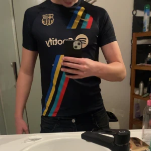 Barca tröja - Säljer denna snygga barcelona tröjan som man kan använda både som sport tröja och vardagligt. Tröjan är köpt i barcelona för ungefär 1 år sedan och är i ett bra skick, det är bara en liten defekt som man knappas ser vid användning som syns på bild 3. Hör av er vid minsta fundering!