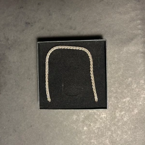 Silverkedja äkta 925 silver - Snyggt silverfärgat halsband med flätad kedja. Perfekt för att ge en stilren touch till din outfit. Kedjan har en klassisk karbinhake och är märkt med 925, vilket indikerar att det är av äkta silver. Köpt för 1400