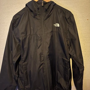 Svart vindjacka från The North Face - Säljer en stilren svart vindjacka från The North Face. Köpt förra året från xxl. Väldigt gott skick