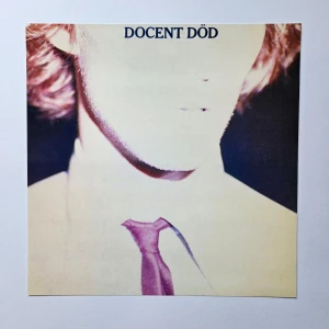 Docent Död - Albumaffisch, 31.5x31.5cm - Docent Död - Docent Död albumaffisch, 31.5x31.5cm   Helt ny - Passar bra i IKEAs tavelram Lomviken!  Skickas i papprulle!