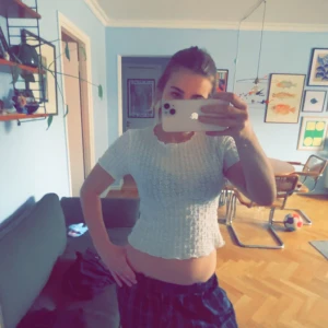 Vit topp - Vit top som inte har några fläckar eller hål, knappt andvänd och har inte kommit till andvändning den har som ett mönster runt hela tröjan (visas på bild 3)