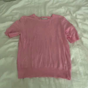 Rosa stickad tröja från H&M - Säljer en söt rosa stickad tröja från H&M med korta ärmar och rund hals. Perfekt för dig som gillar mjuka och sköna material. Enkel design som är lätt att matcha med jeans eller kjol. Passar dig som vill ha en chill och färgglad look.