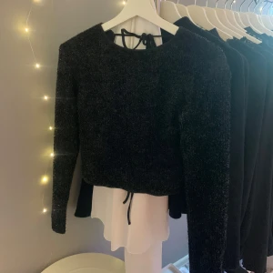 Svart glittrig tröja - Säljer en svart glittrig topp från Bik Bok med öppen rygg och knytband. Aldrig använd, storlek M, nypris 299kr. Finns fler bilder ner i flödet när jag har en likadan tröja i rosa ifall du vill se hur den sitter på🤍