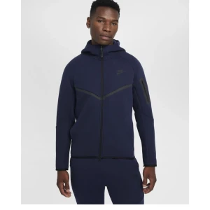 Marinblå Nike hoodie med dragkedja - Snygg marinblå Nike tech suit med hel dragkedja och huva. Den är nästintill oanvänd och i väldigt bra skick, därav priset! Överdelen är i storlek S och och byxorna i storlek XL så vid intresse av endast en av klädesplaggen kontakta mig så fixar jag en enskild annons åt den! 1150 kr för byxorna och 1350 kr för överdelen. Den är köpt på herravdelningen men passar kvinnor också! Pris kan möjligtvis diskuteras!😁