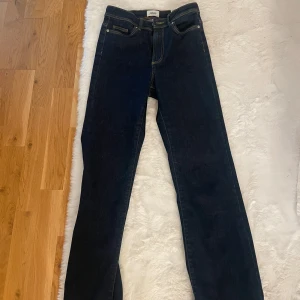 Mörkblå bootcut jeans från ONLY XS - Snygga mörkblå jeans från ONLY i bootcut-modell med klassiska fem fickor och kontrastsömmar. Jeansen har normal passform och är tillverkade i jeansmaterial med dragkedja och knapp framtill.💙💙💙