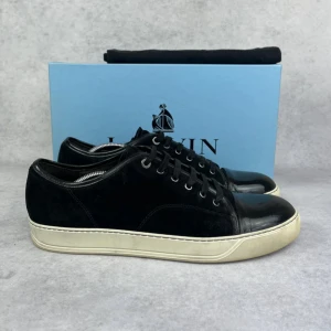 Lanvin DBB1 cap toe sneaker - – Condition: 8/10  - Size: 46/UK12  – What is included: Dustbag  – Retail price: 5000 + SEK  Please note that Lanvins fit big and our recommendation is to go one size down