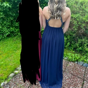 Marinblå balklänning från Nelly Eve - Säljer min marinblåa balklänning från Nelly Eve i storlek 36. Klänningen har öppen rygg med snygga axelband dekorerade med pärlor och stenar. Modellen är oneshoulder och har ett flowigt tyg med slits som ger en elegant look. Perfekt för bal eller student!✨✨