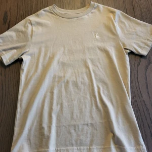 Beige t-shirt från Polo Ralph Lauren - Snygg beige t-shirt från Polo Ralph Lauren. Mycket fint skick. Använd ca 2 gånger. 
