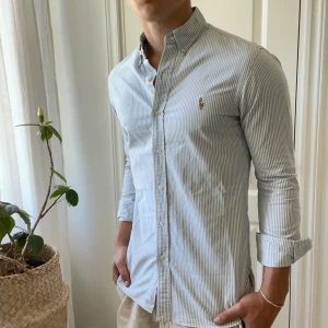 Ralph Lauren skjorta slim fit randig  - Ralph Lauren skjorta i storlek S slim fit, modellen är 180,75 kg kom med frågor! Kom med frågor 🫶 inga större defekter men en extremt minimalt defekt vid ärmen då skjortan har använts tidigare, kolla på bilden så fattar ni! Kommer knappt se det. 