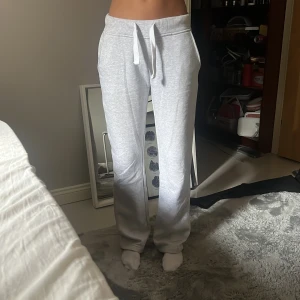 Russemerch - Supermysiga ljusgrå mjukisbyxor från Russemerch i Long Edition i storlek XS. De har normal passform, raka ben och snörning i midjan. Tillverkade i mjukt bomullsmaterial med två sidofickor. Innerbenslängd 79cm!🩷