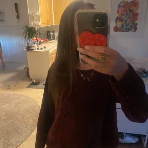 Vinröd stickad tröja från KappAhl - Mysig vinröd stickad tröja från KappAhl i storlek 158/164. Tröjan har en rund halsringning och långa ärmar med ribbade muddar. Perfekt att slänga på sig när det är kyligt ute och funkar lika bra till jeans som till mjukisbyxor.