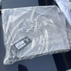 Beige chinos från Lindbergh - Snygga beige chinos från Lindbergh med klassisk design och raka ben. Byxorna har diskreta fickor och är tillverkade i ett mjukt bomullsmaterial som ger en skön känsla. Perfekta för en clean och stilren look. Shorts