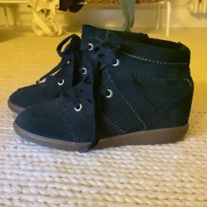 Isabel Marant svarta mocka sneakers - Svarta sneakers från Isabel Marant i mjuk mocka med snygga sömdetaljer och snörning framtill. Skorna har en platt gummisula i brunt och en rund tå. Perfekta för dig som gillar stilrena och coola skor med exklusiv känsla💕