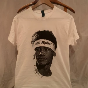Vit t-shirt med Neymar JR ”100% Jesus” - Jag säljer en Neymar T-Shirt. Jag köpte den för 450kr ungefär men den var fel storlek och jag kunde ej byta den. Den är helt ny och oanvänd. På framsidan är det Neymar som har ett pannband ”100% Jesus” och baksidan är det brasilianska fotbollslagets logga. Har du några frågor är det bara att höra av dig, priset kan diskuteras😁