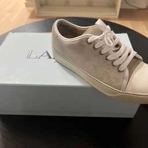 Beige sneakers från Lanvin - Snygga beige sneakers från Lanvin i mocka med vita snören och en vit sula. Perfekta för en kommande vår (bytt snören) 