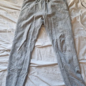 Grå mjukisbyxor från Andy by Frank Dandy - Säljer ett par grå mjukisbyxor från Andy by Frank Dandy. De har en elastisk midja och är gjorda i mjukt bomullsmaterial. Bra längd på mig som är 164 cm💕