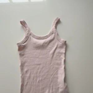 Ljusrosa ribbad linnetopp från Gina Tricot - Säljer en ljusrosa ribbad linnetopp från Gina Tricot. Perfekt för varma dagar med sin enkla och stilrena design. Toppen har smala axelband och är tillverkad i ett mjukt material för extra komfort.