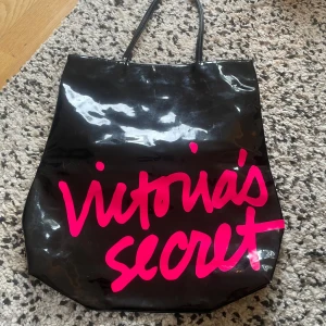 Svart shoppingväska från Victoria's Secret - Snygg svart shoppingväska från Victoria's Secret med rosa text. Super Rare!! Äkta från 2000s och de finns inte längre att köpa 💕💕