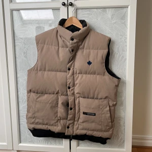 Beige dunväst från Canada Goose - Säljer en snygg beige dunväst från Canada Goose. Skick 9/10. Använd en del men med försiktighet. Bara någon defekt som syns på sista bilden! Hör av dig vid frågor eller funderingar!