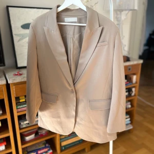 Beige Oversized Kavaj - Stilren beige oversized kavaj som passar till både vardag och fest. Ledig passform för en avslappnad och modern look.