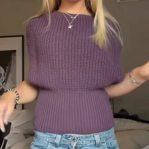 Vinröd stickad tröja - Säljer en snygg lila stickad tröja med en unik design. Tröjan har en bred ribbad midja och en lös passform upptill. Perfekt för att hålla sig varm och stilren under kyligare dagar.