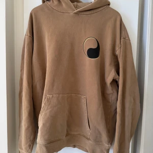 Our Legacy & Stüssy - Säljer en beige hoodie från Our Legacy Workshop & Stüssy. Tillverkad av 100% bomull, varav 50% är återvunnet och 50% ekologiskt. Storlek XL och passar precis som en XL. 