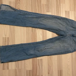 Blå jeans från H&M - Säljer ett par klassiska blå jeans från H&M. De har en rak passform och är perfekta för en avslappnad stil. Jeansen har en knapp och dragkedja framtill samt fickor både fram och bak.