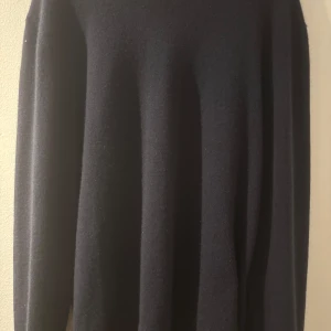 Svart kashmirtröja från A Day's March - Säljer en elegant svart tröja i ren kashmir från A Day's March. Tröjan har en klassisk design med långa ärmar och rund hals. Perfekt för att hålla dig varm och stilren under kyligare dagar. Storlek L och ny pris går för 2500