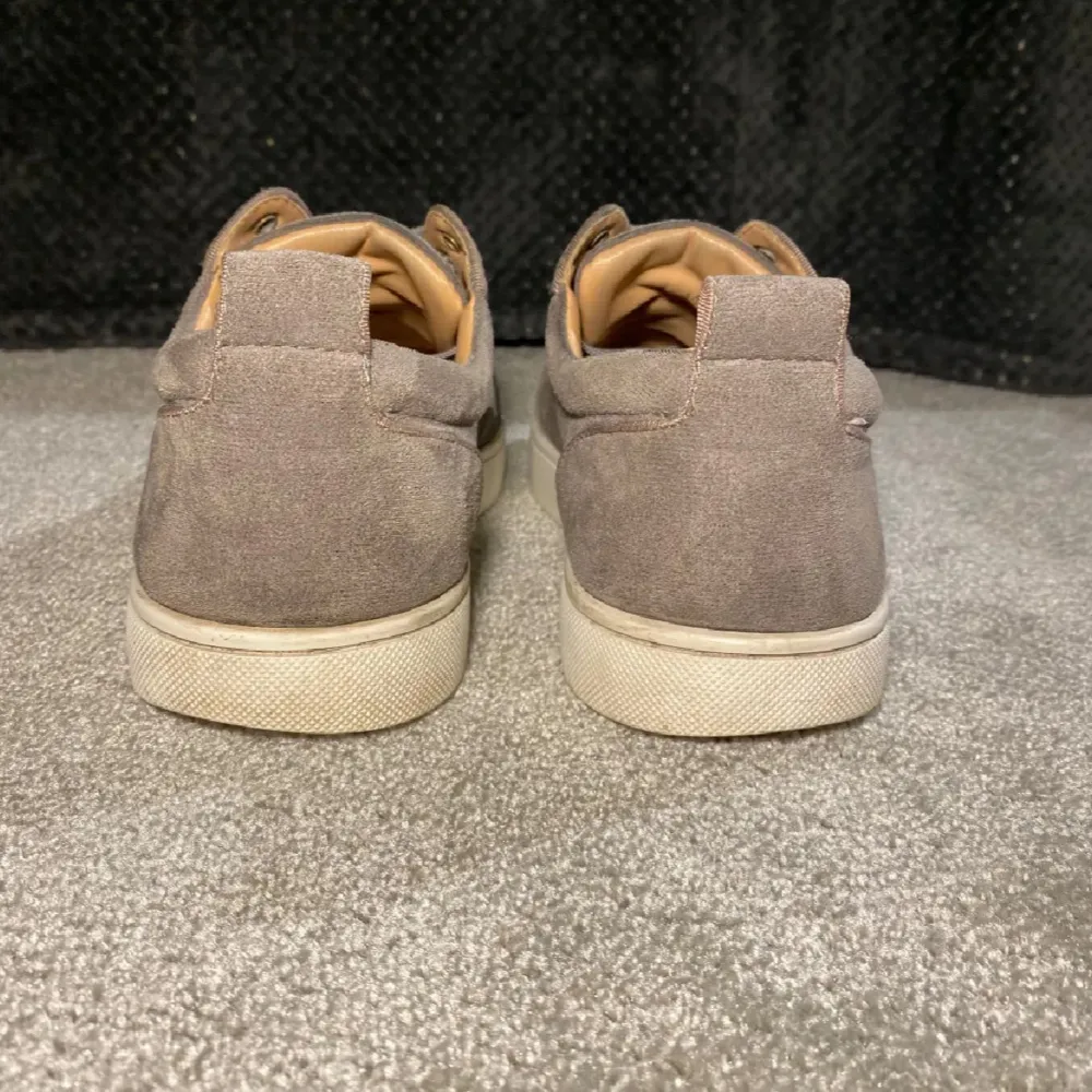 Snygga grå sneakers från Christian Louboutin i mocka med den ikoniska röda sulan. Skorna har snörning och en stilren design som passar perfekt för en trendig look. Levereras med originalförpackning och dustbag. Byten funkar men helst pengar. Kengät.