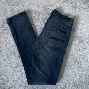 Nudie Jeans  - Tja! Säljer dem här snygga och efterfrågade Nudie Jeansen, Storlek W29 L32, Skick 9/10, Färg mörkgrå, Nypris cirka 1600 nu endast 399kr! Hör av er vid minsta lilla fråga eller fundering! 