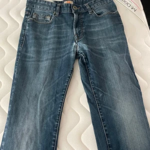 Blå jeans från Boss Orange - Snygga blå jeans från Boss Orange med regular fit. Klassisk design med fem fickor och knappgylf. Perfekta för en avslappnad stil.