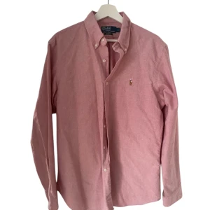 Rosa skjorta från Ralph Lauren - Snygg rosa skjorta från Ralph lauren. Skjortan är slim Fit 100% bomull i storlek-L                                                     Skjortan är endast använd en gång! Och i toppskick.                                                                      Nypris 1300kr.                                                                      Hör av er vid frågor! 