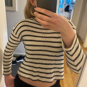Randig stickad tröja - Säljer denna randiga stickade tröja i svart och vit. Tröjan är i en croppad passform och långa ärmar, perfekr nu till våran och sommaren. Den är väldigt tunn och har använts mycket men inga synliga defekter. Säljer då den inte kommer till användning längre.💕💕 
