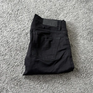 Svarta tiger of Sweden, Blaise jeans 29/34 - Snygga svarta jeans från tiger of Sweden, Blaise i modellen. De har en slim passform med raka ben och klassisk femficksdesign. Perfekta för dig som gillar stilrena och enkla jeans med modern look. Storlek 29/34.