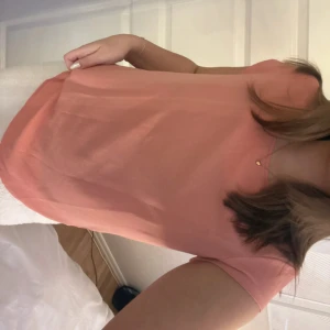 Persikofärgad blus från ONLY - Säljer en persikofärgad blus från ONLY i storlek 36. Blusen har rund halsringning, korta ärmar och en snygg dragkedja bak. Materialet är lätt strukturerat och känns skönt mot huden. Perfekt för dig som gillar stilrena och fräscha toppar.